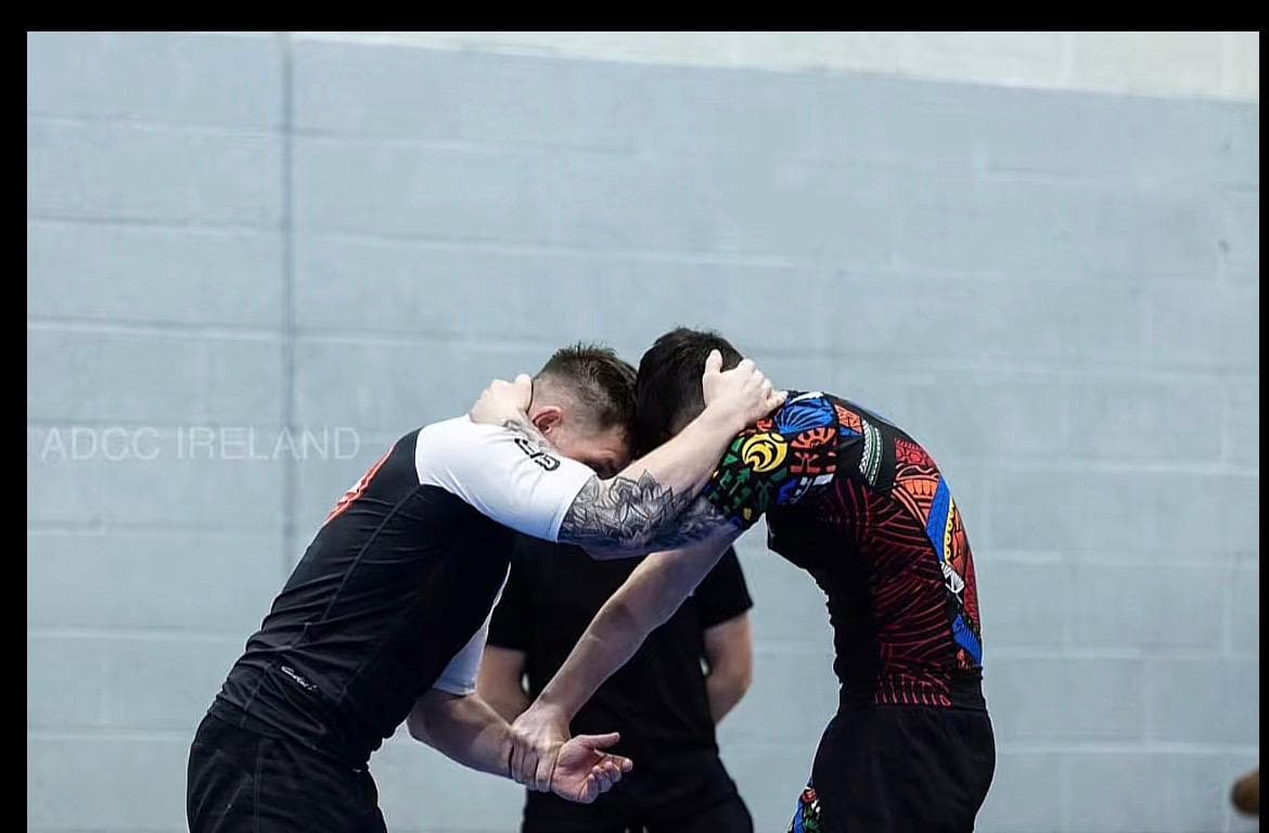 Two grapplers clinching on the competition floor at ADCC Ireland